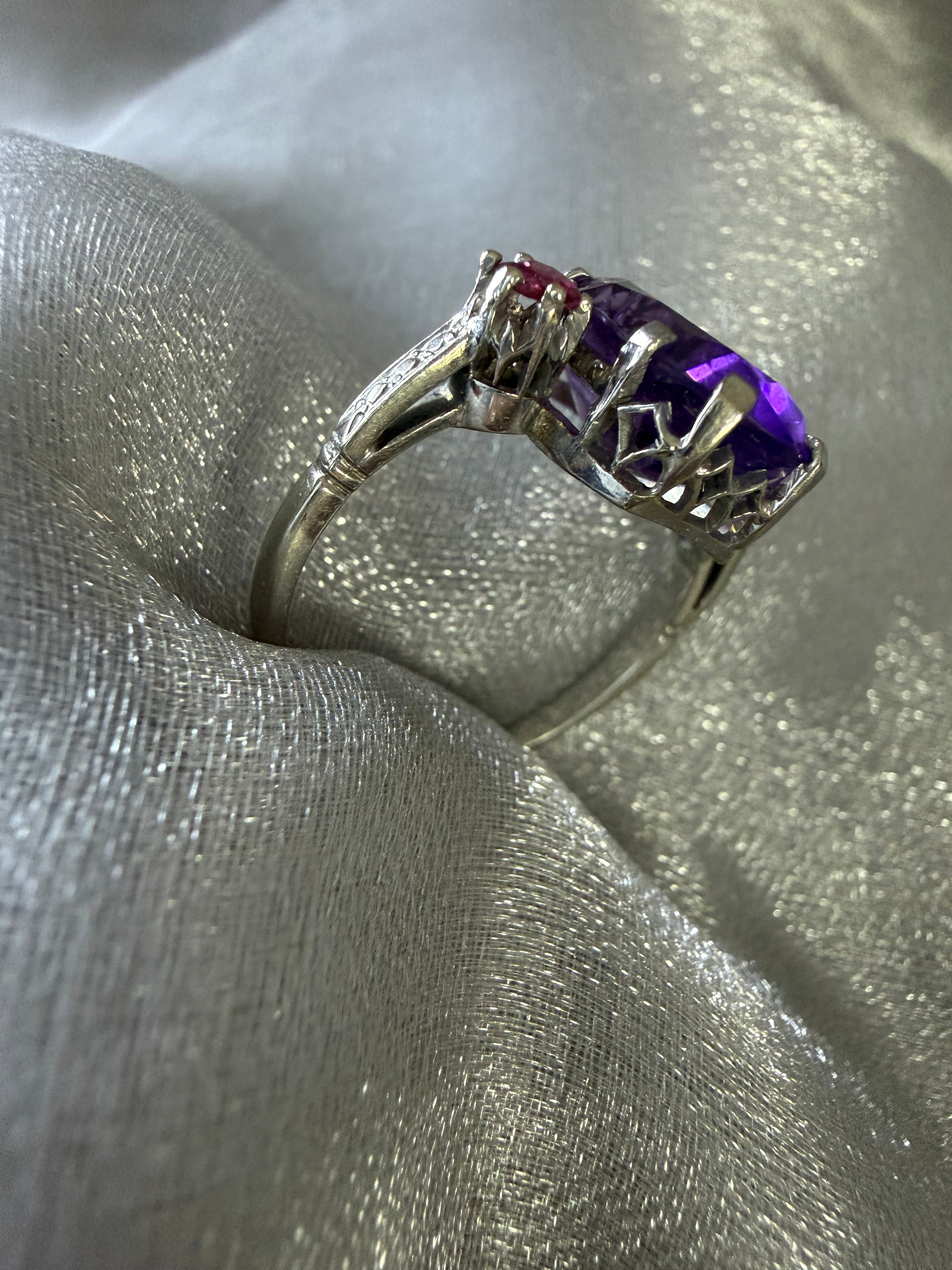 Close-up of deep violet oval amethyst and warm red natural ruby accents in Art Deco ring