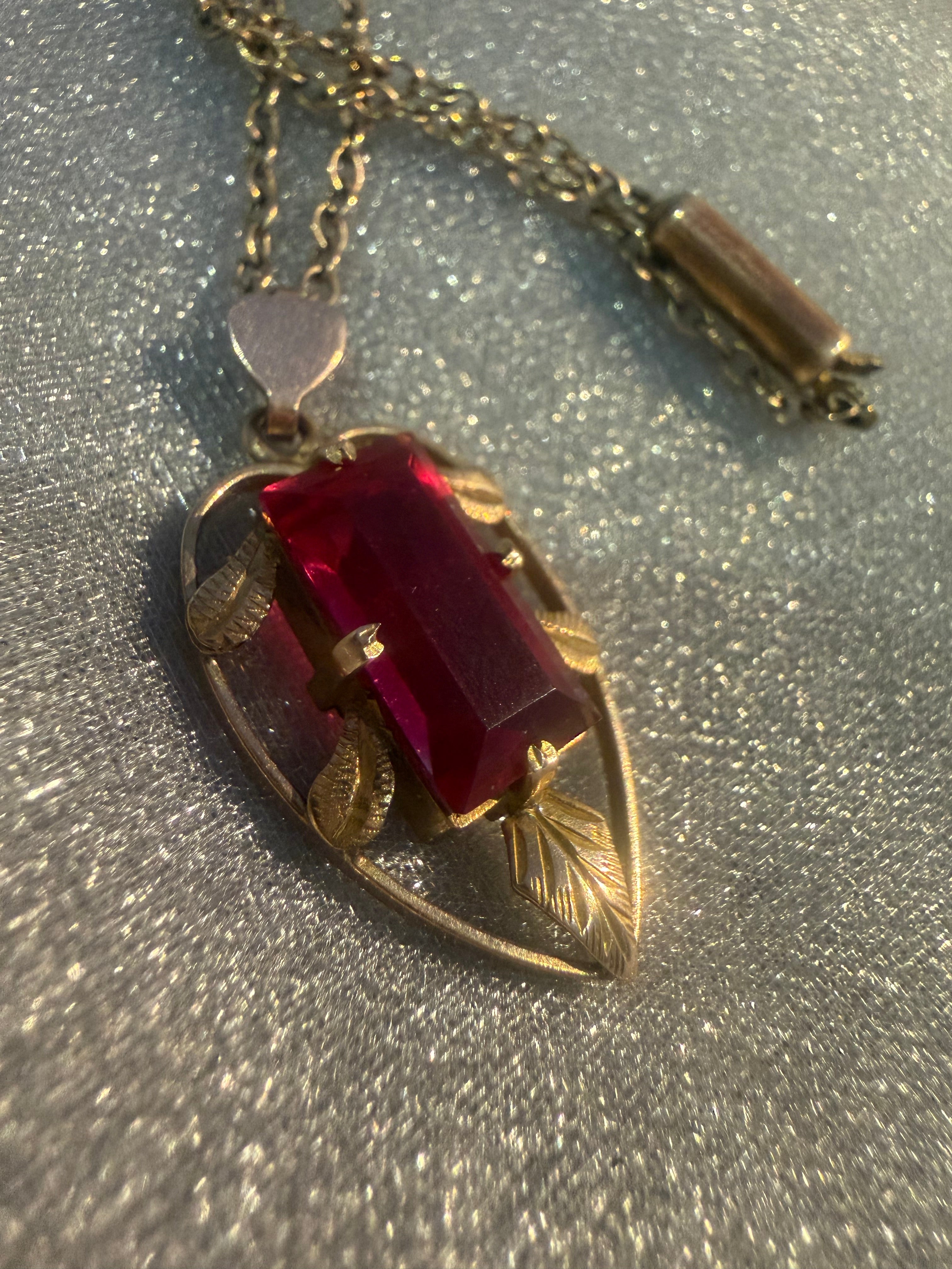 Vintage Lustre 9ct gold pendant, crimson stone in engraved leaf setting, close-up