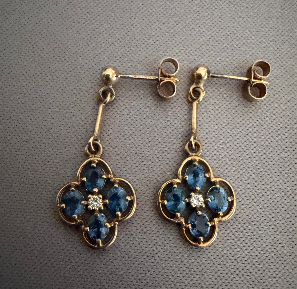 Front view of 9ct gold sapphire and diamond clover drop earrings showing articulated drop and stone arrangement
